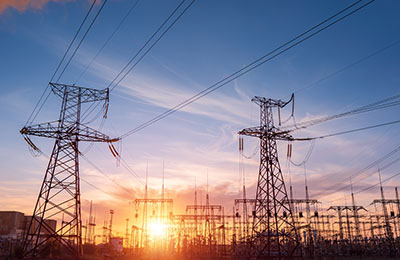 High-voltage power lines at sunset or sunrise. High voltage electric transmission tower