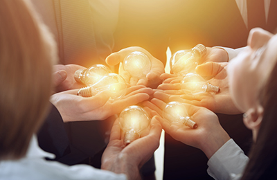 Teamwork and brainstorming concept with businessmen that share an idea with a lamp. Concept of startup